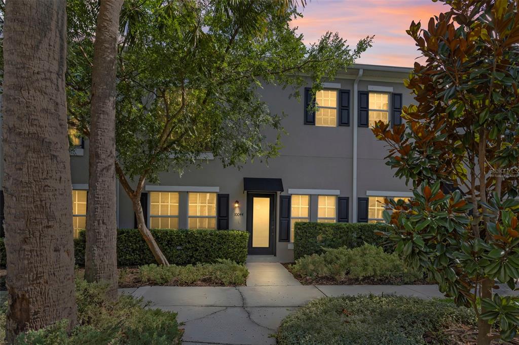 A two-story townhouse exterior features a front walkway, manicured hedges, and large windows — 10044 OLD HAVEN WAY, TAMPA, FL