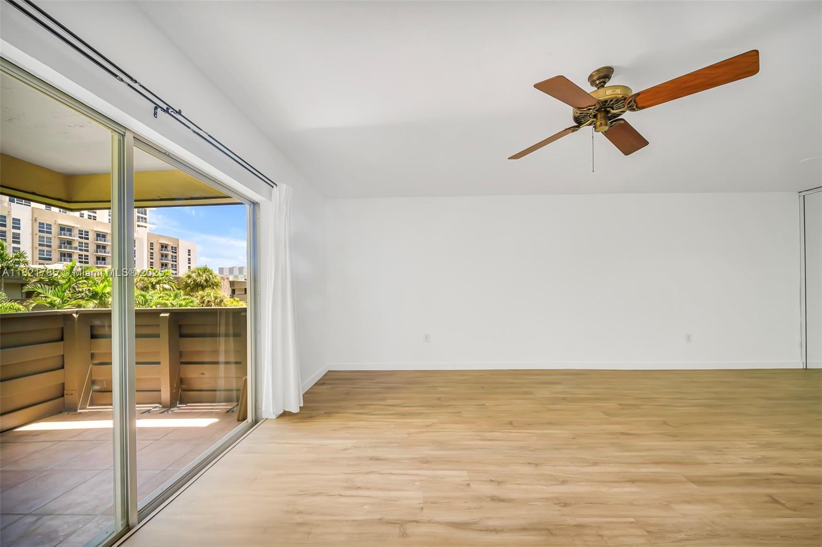 An empty room with light wood-look flooring, a ceiling fan, and a sliding glass door — 8335 SW 72nd Ave # 315D, Miami FL 33143, MIAMI, FL