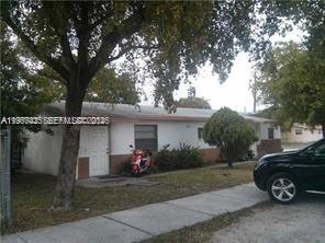 A single-story white house with a brown base sits behind a tree and sidewalk — 2100 NW 4th St, Pompano Beach FL 33069, POMPANO BEACH, FL
