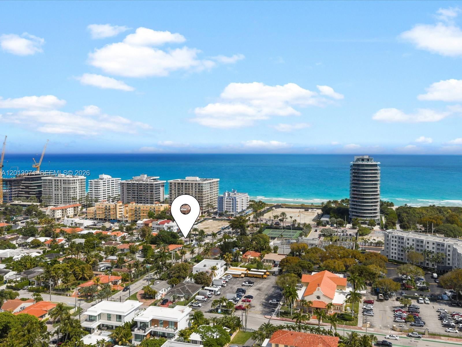 An aerial view shows a coastal city with high-rise buildings, residential homes, and the ocean — 301 88th St, Surfside FL 33154, SURFSIDE, FL