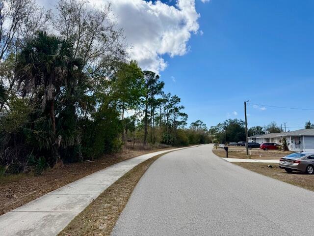 A paved street with a sidewalk runs alongside a wooded area and residential houses — 4921 S Fairway Drive, Punta Gorda FL 33982, PUNTA GORDA, FL