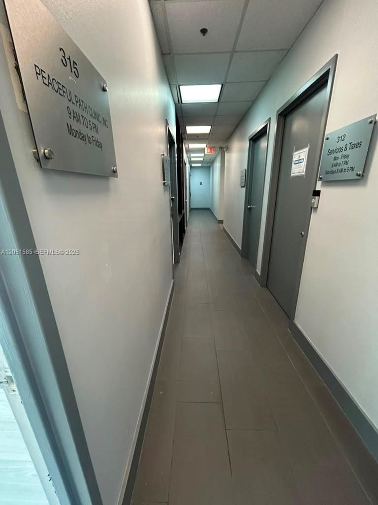 A narrow office hallway features grey tile flooring, white walls, and several numbered office doors — 900 W 49th St Suite 315, Hialeah FL 33012, HIALEAH, FL
