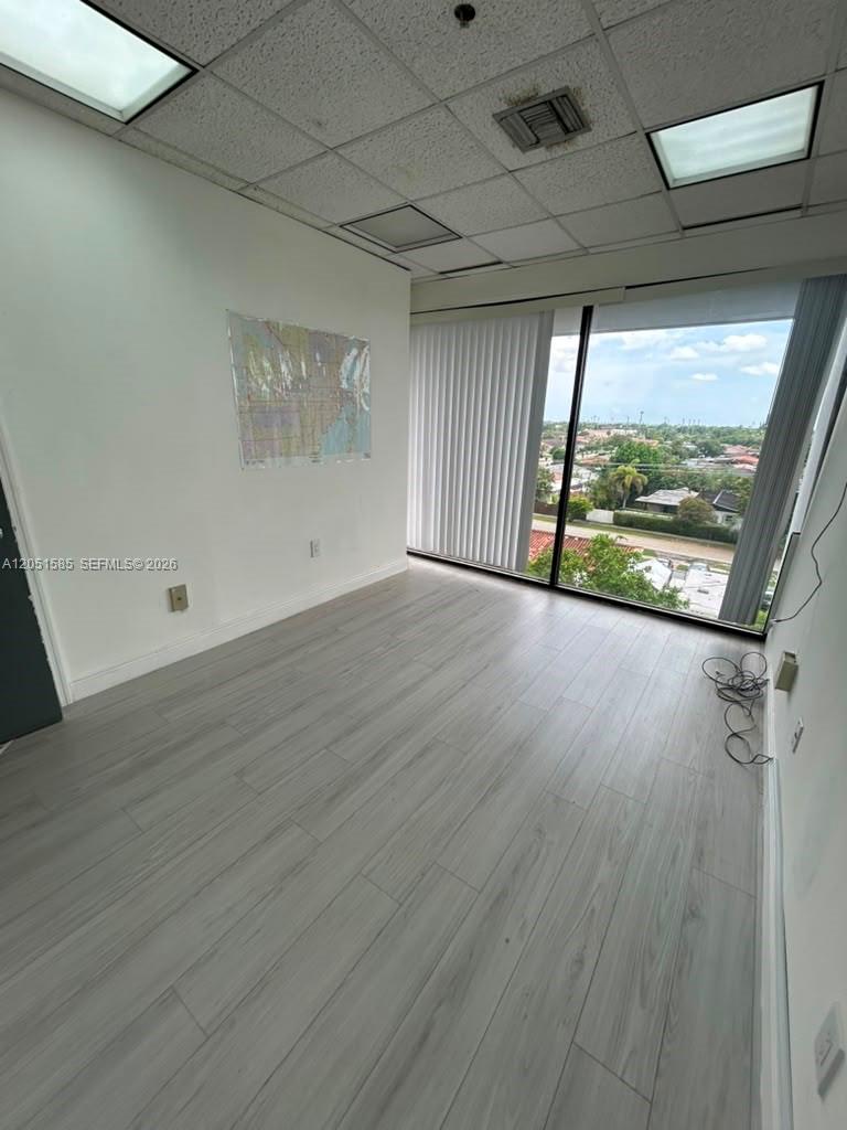 An office space features light wood-look flooring, a drop ceiling, and large windows with views — 900 W 49th St Suite 315, Hialeah FL 33012, HIALEAH, FL