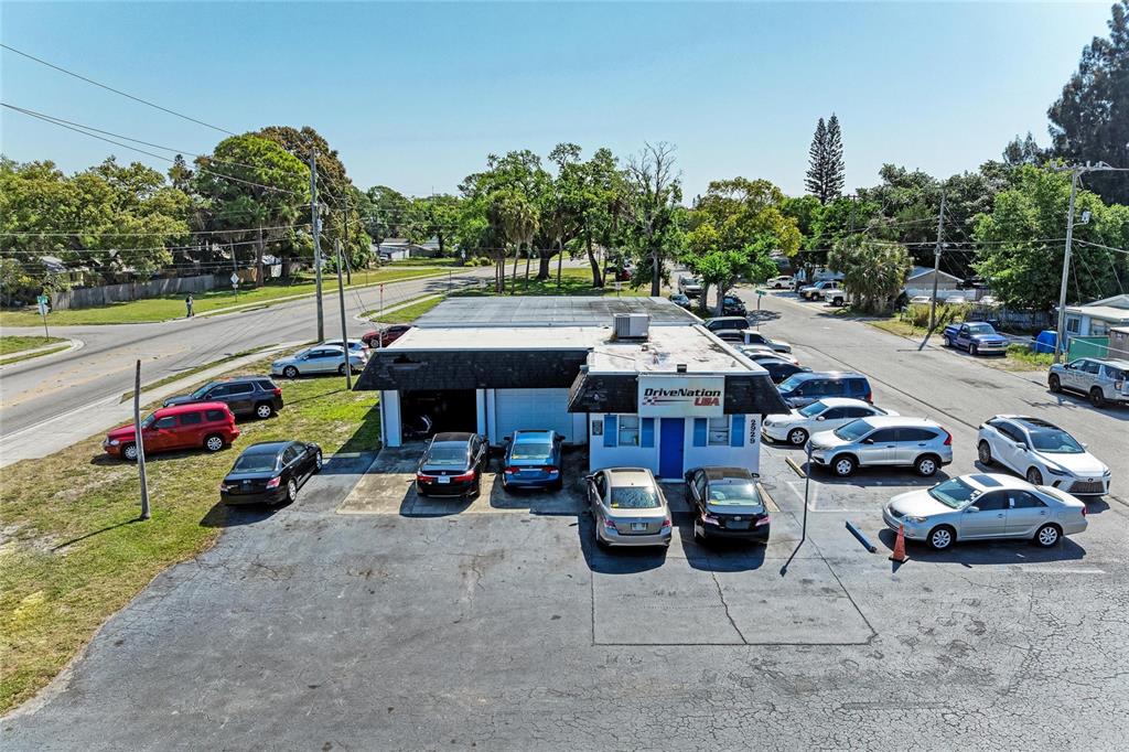 An aerial view shows a commercial building with a parking lot filled with various cars — 2929 9TH STREET W, BRADENTON, FL