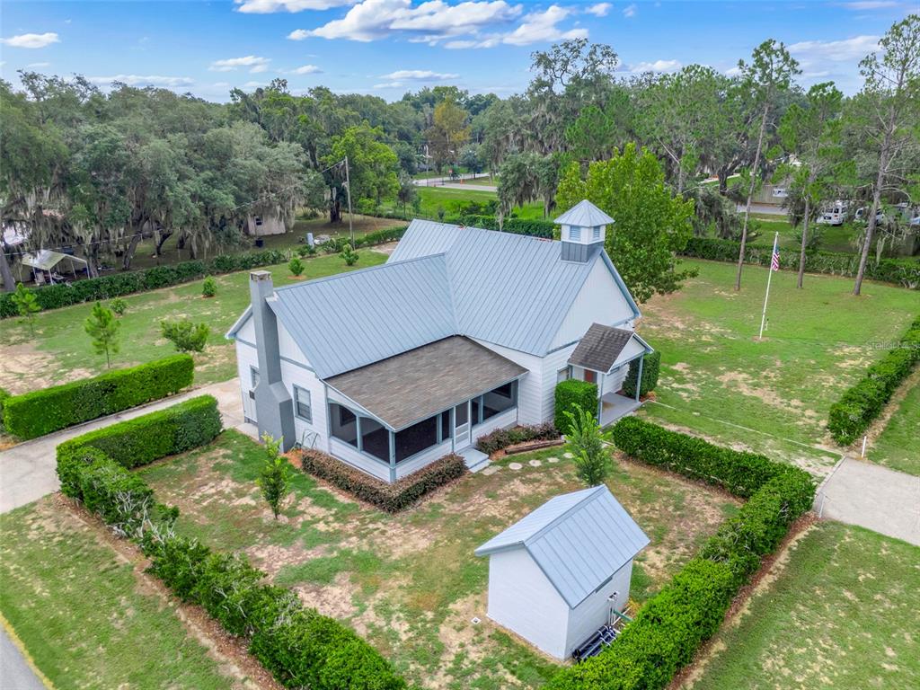 An aerial view shows a white house with a metal roof, cupola, and screened porch — 13234 SOUTH CAROLINA AVENUE, ASTATULA, FL