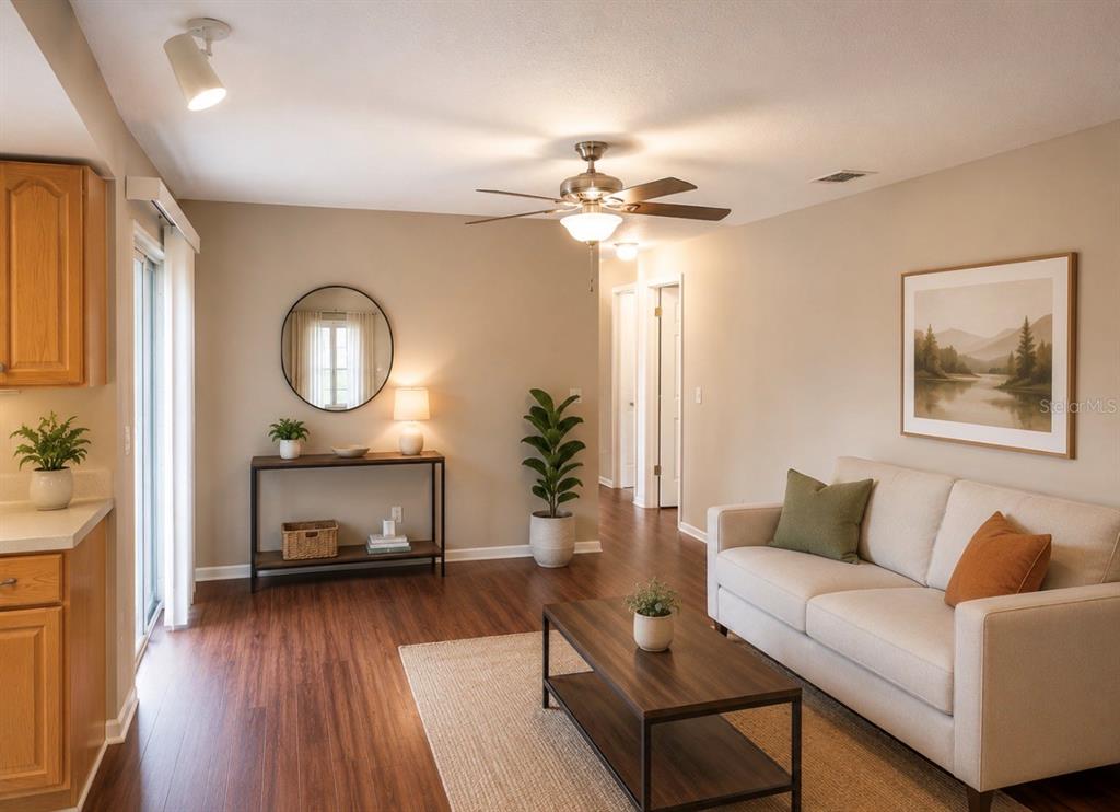 A living room with wood-look flooring, a beige sofa, a coffee table, and a console table — 1840 ASTER DRIVE, WINTER PARK, FL