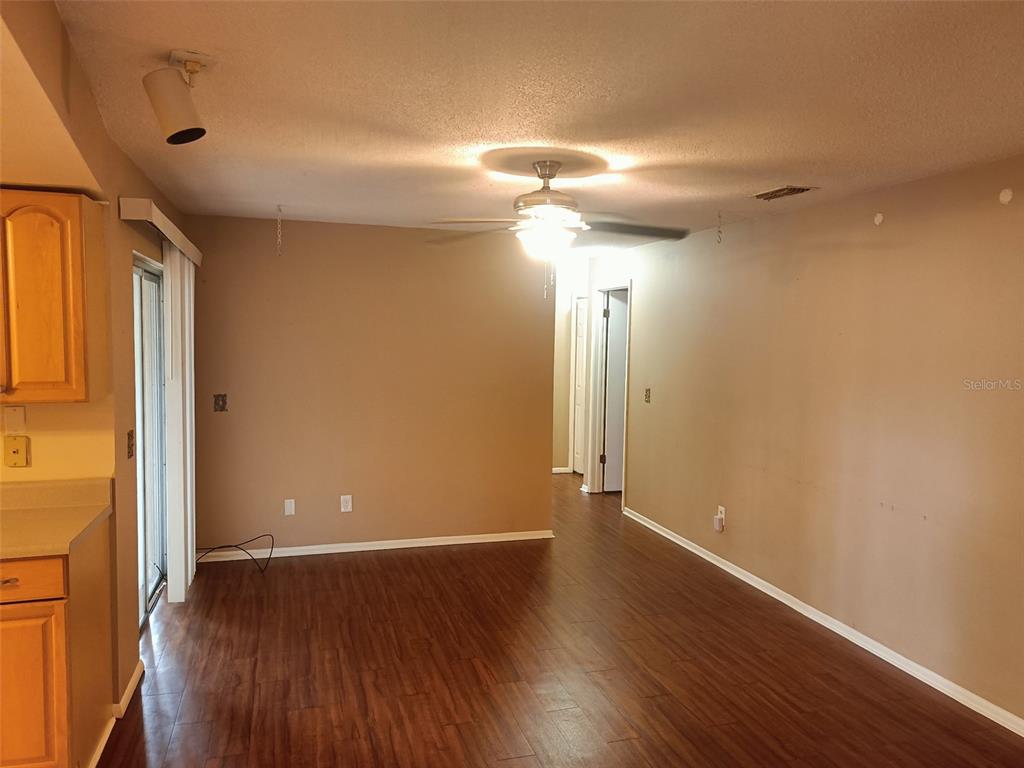 An interior view of a room with wood-look flooring, a ceiling fan, and beige walls — 1840 ASTER DRIVE, WINTER PARK, FL