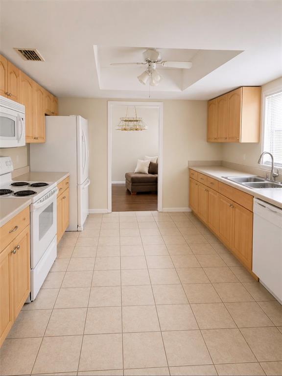 A kitchen with light wood cabinets, white appliances, and beige tile flooring — 1840 ASTER DRIVE, WINTER PARK, FL