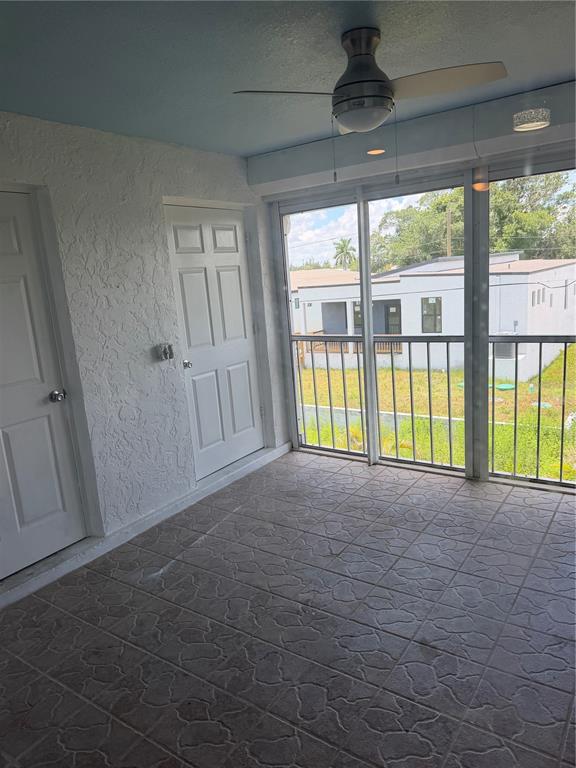 A sunroom with a blue ceiling, tiled floor, ceiling fan, and a metal-railed balcony view — 2735 MAGDALINA DRIVE UNIT 2, PUNTA GORDA, FL
