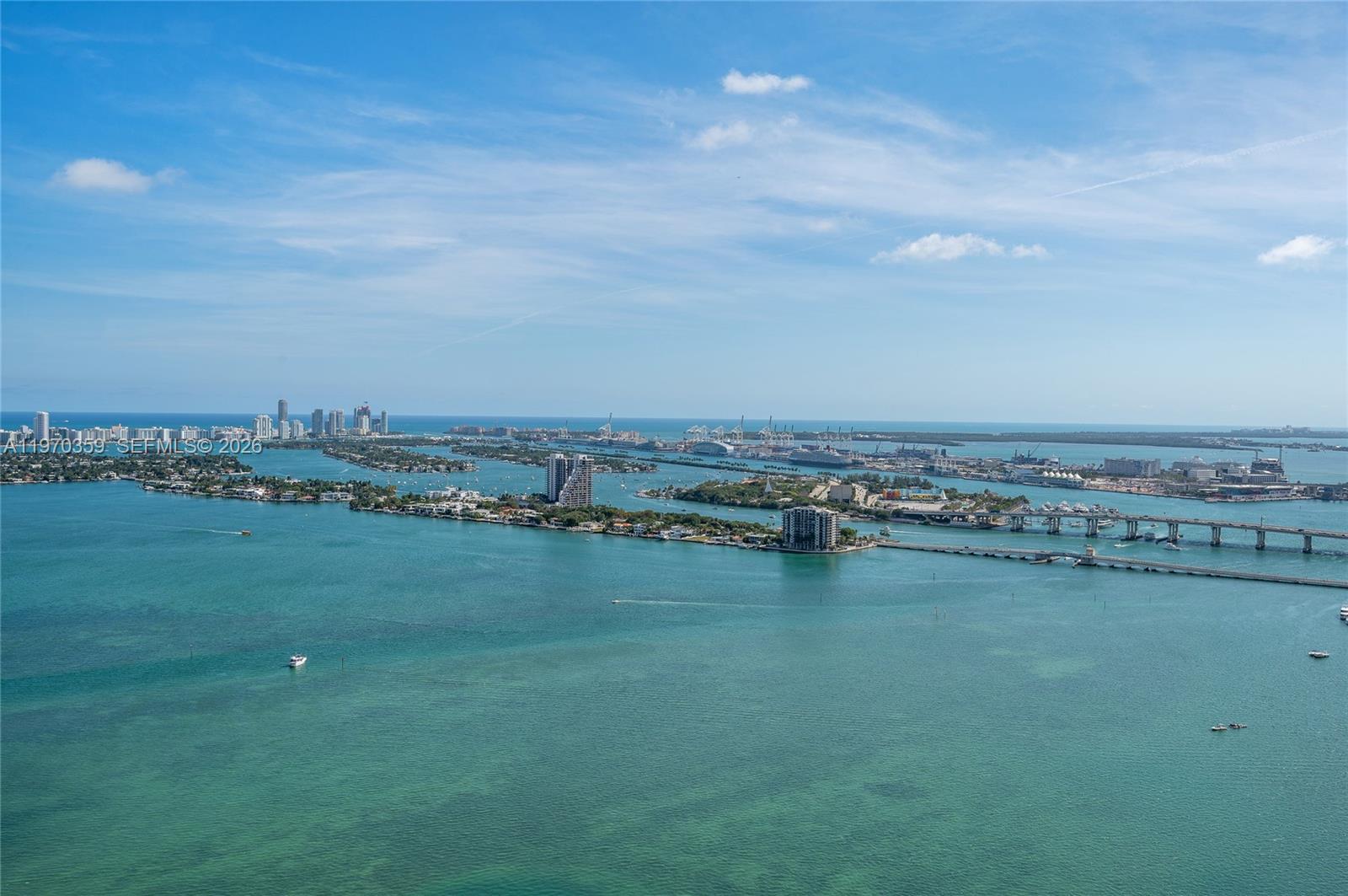 An aerial view shows islands, bridges, and the Miami skyline across a turquoise bay — 700 NE 24th Street, Miami FL 33137, MIAMI, FL