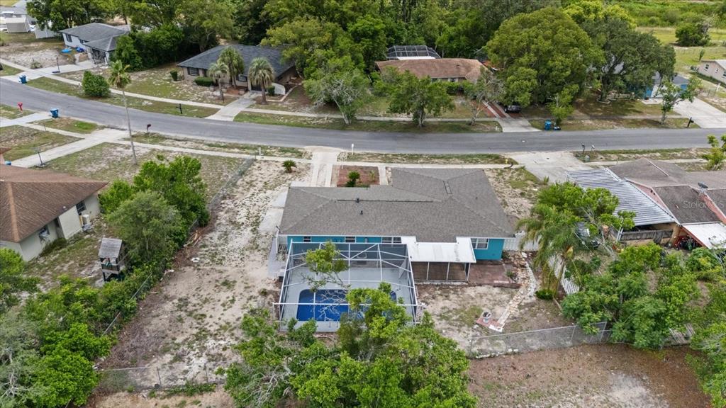 An aerial view of a single-story house with a screened-in pool and a large yard — 6495 FAIRLAWN STREET, SPRING HILL, FL