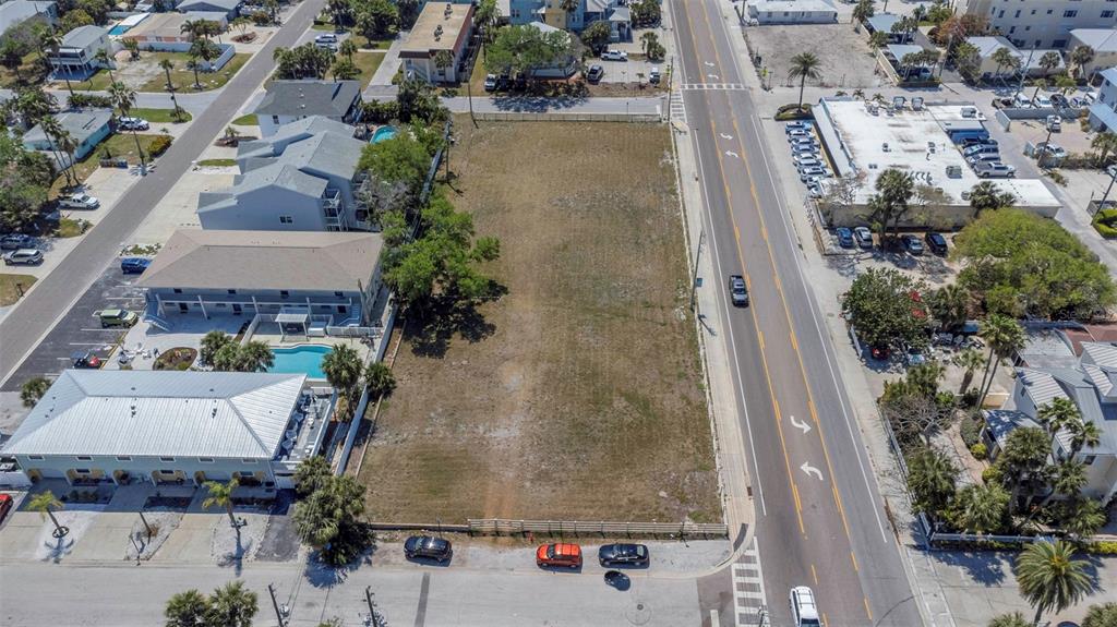An aerial view shows a vacant rectangular lot situated between a road and residential buildings — 2300 GULF BOULEVARD, INDIAN ROCKS BEACH, FL