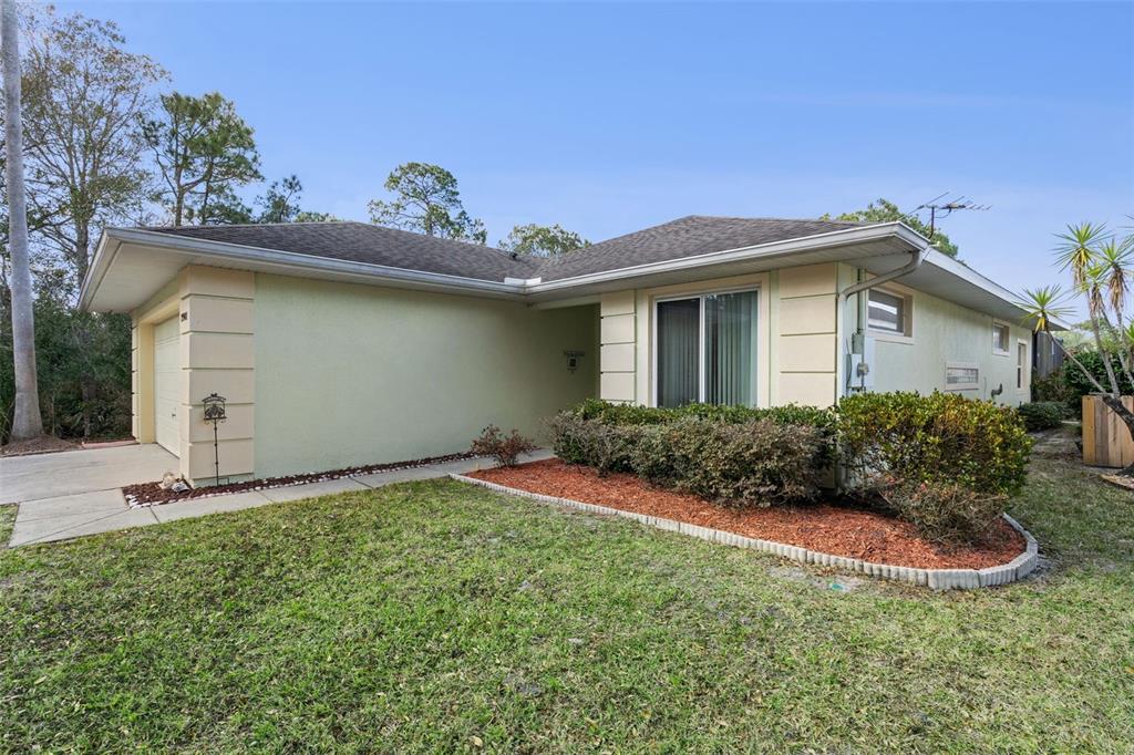 A single-story house with a light green exterior, a garage, and a landscaped front yard — 2901 SUNSET VISTA COURT, KISSIMMEE, FL