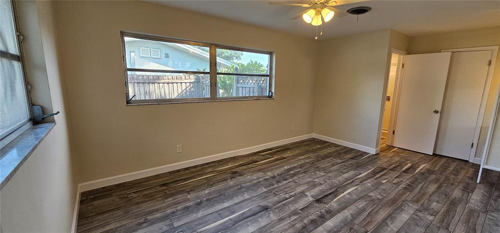 An empty bedroom features light-colored walls, a ceiling fan, and wood-look flooring — 1329 FAIRFIELD DRIVE, CLEARWATER, FL