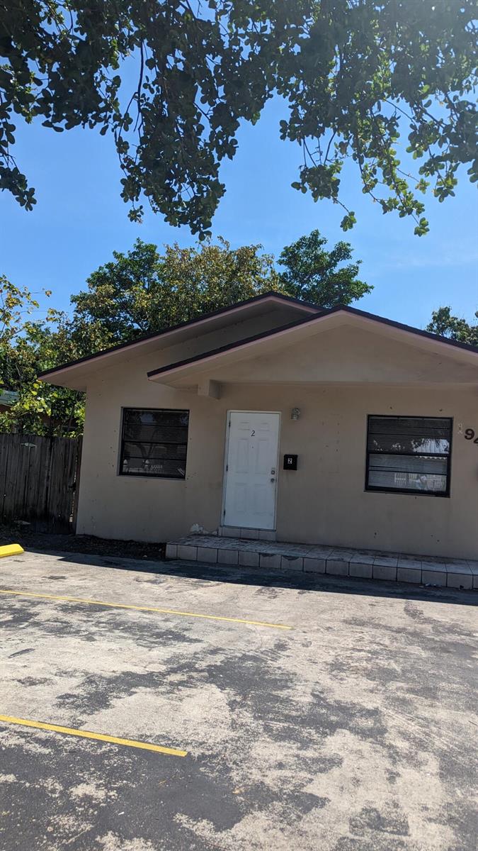 A single-story tan building with a white front door and two windows faces a parking lot — 1944 Taft Street, Hollywood FL 33020, HOLLYWOOD, FL