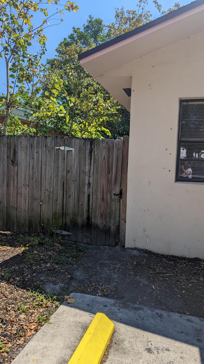 A wooden fence stands next to the exterior wall of a building with a window — 1944 Taft Street, Hollywood FL 33020, HOLLYWOOD, FL