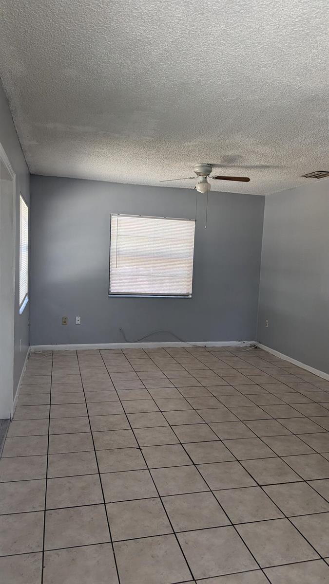 An empty room with gray walls, a ceiling fan, and light-colored square floor tiles — 1944 Taft Street, Hollywood FL 33020, HOLLYWOOD, FL