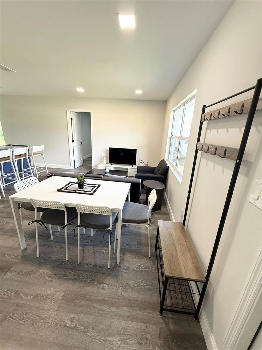 A dining area with a white table and chairs sits next to a living space — 801 Broadhag Dr, Punta Gorda FL 33950, PUNTA GORDA, FL
