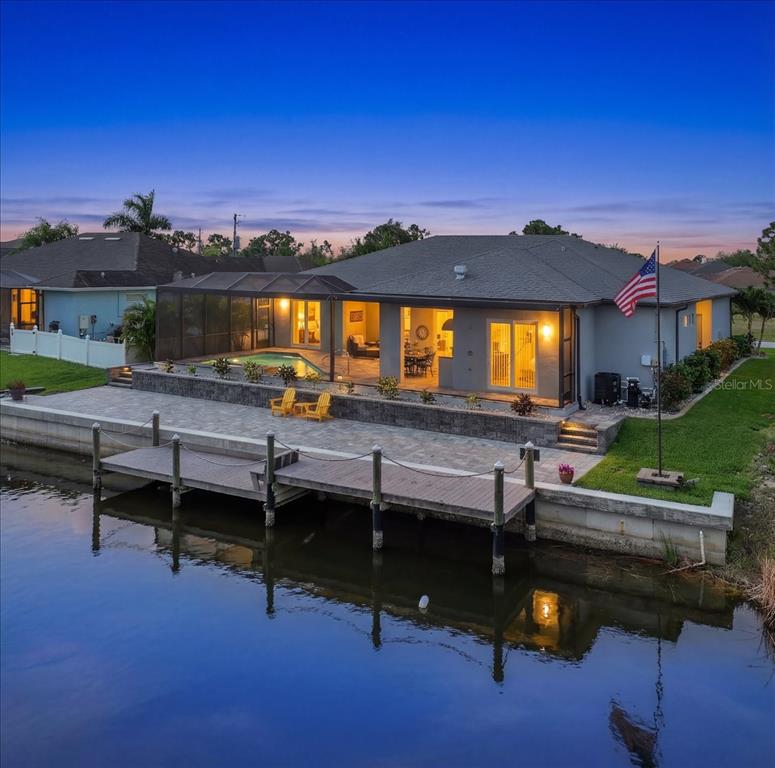 An aerial view of a waterfront house with a pool, patio, and private wooden dock — 9214 MELODY CIRCLE, PORT CHARLOTTE, FL