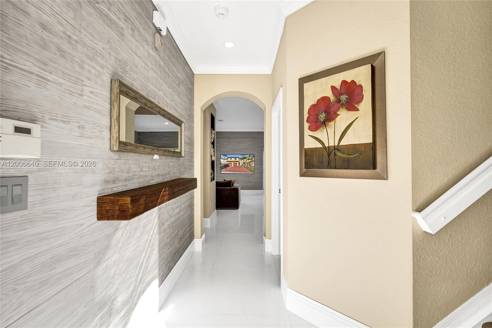 A hallway features a wood-paneled accent wall, a floating shelf, and a floral painting — 5144 SW 141st Ter, Miramar FL 33027, MIRAMAR, FL
