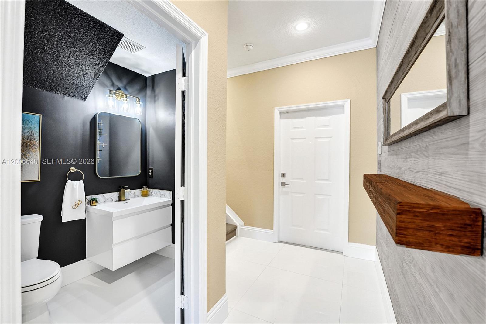 A white-tiled entryway leads to a powder room with black walls and a floating vanity — 5144 SW 141st Ter, Miramar FL 33027, MIRAMAR, FL