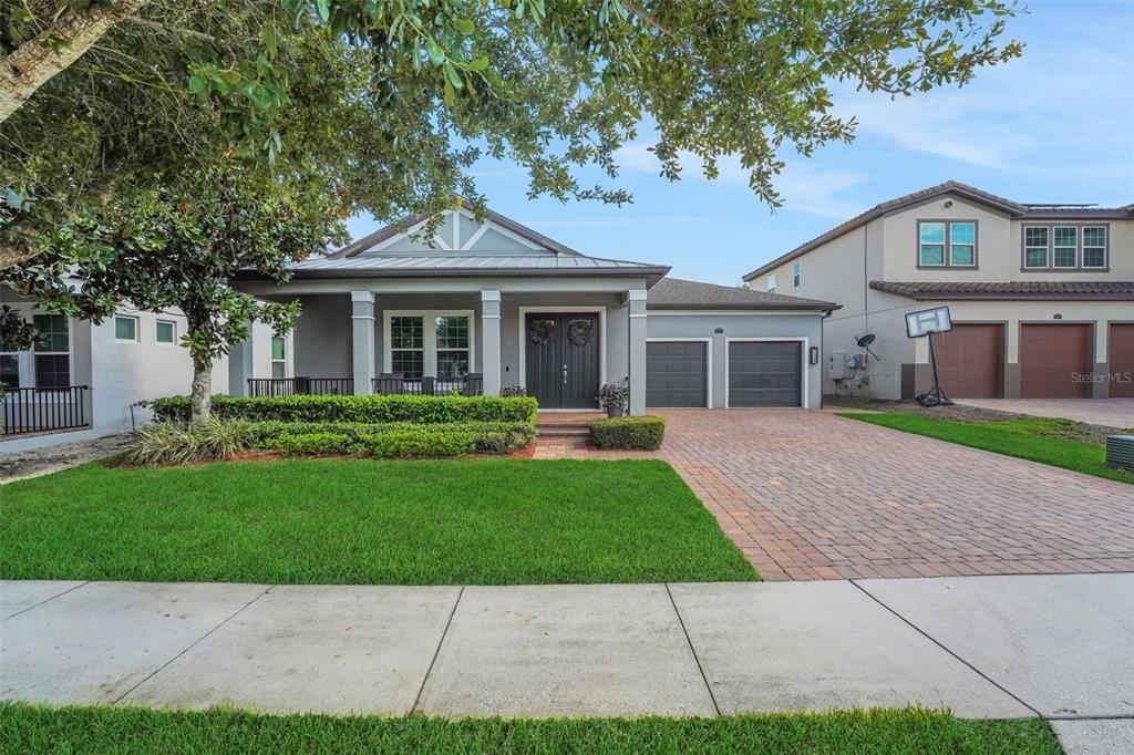 A single-story gray house with a brick driveway and a front porch — 16736 GULLFLOSS TERRACE, WINTER GARDEN, FL