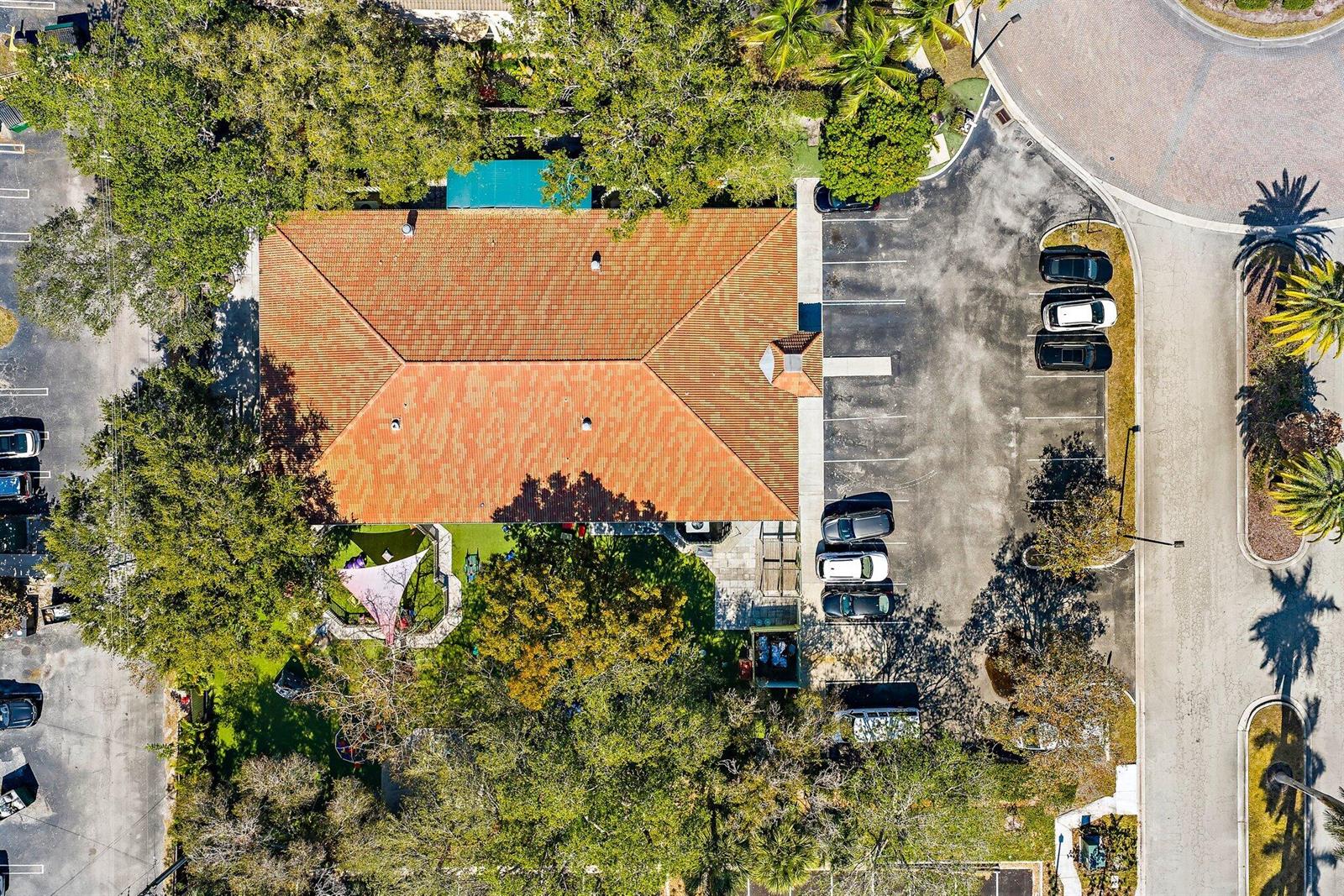An aerial view shows a building with a terracotta roof, parking lot, and playground — 100 Intracoastal Pointe Drive, Jupiter FL 33477, JUPITER, FL