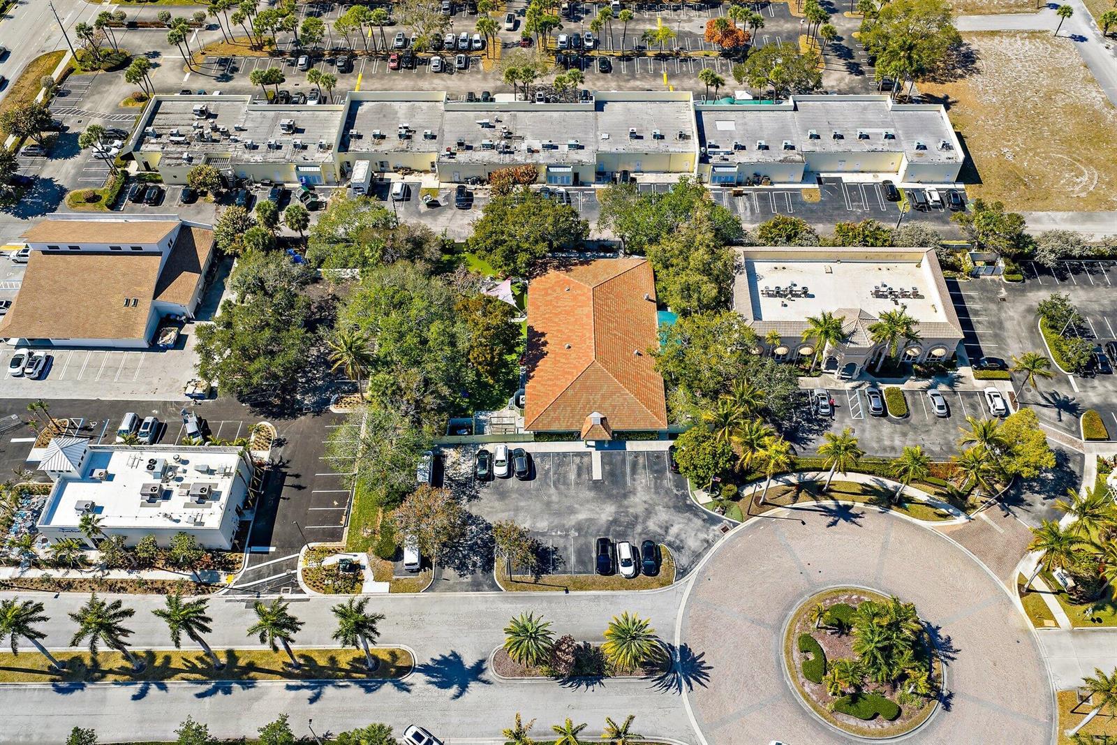 An aerial view shows a commercial building with a terracotta roof surrounded by parking lots — 100 Intracoastal Pointe Drive, Jupiter FL 33477, JUPITER, FL