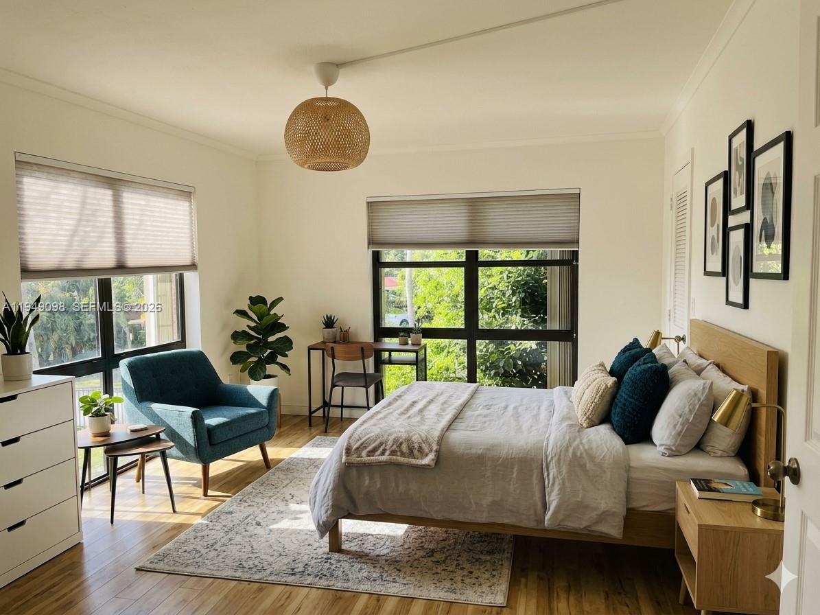 A bedroom with a bed, a blue armchair, a desk, and large windows with blinds — 1650 NE 115th St # 311, Miami FL 33181, MIAMI, FL
