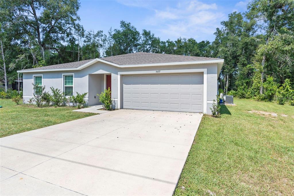 A single-story house with a gray exterior, a two-car garage, and a concrete driveway — 5637 E TANGELO LANE, INVERNESS, FL