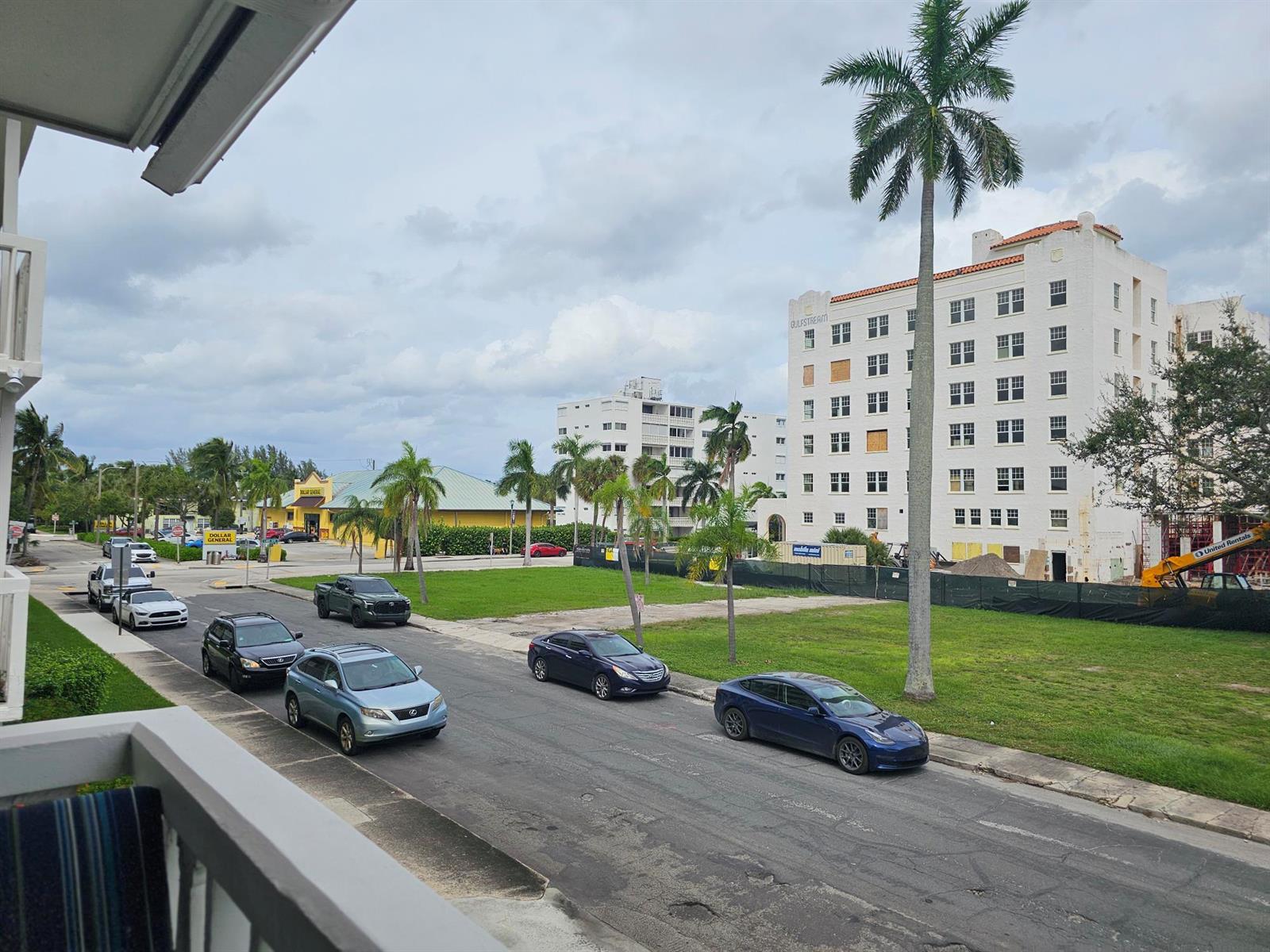 An elevated view of a street with parked cars, palm trees, and a large white building — 17 S Lakeside Drive # 4, FL 33460, FL