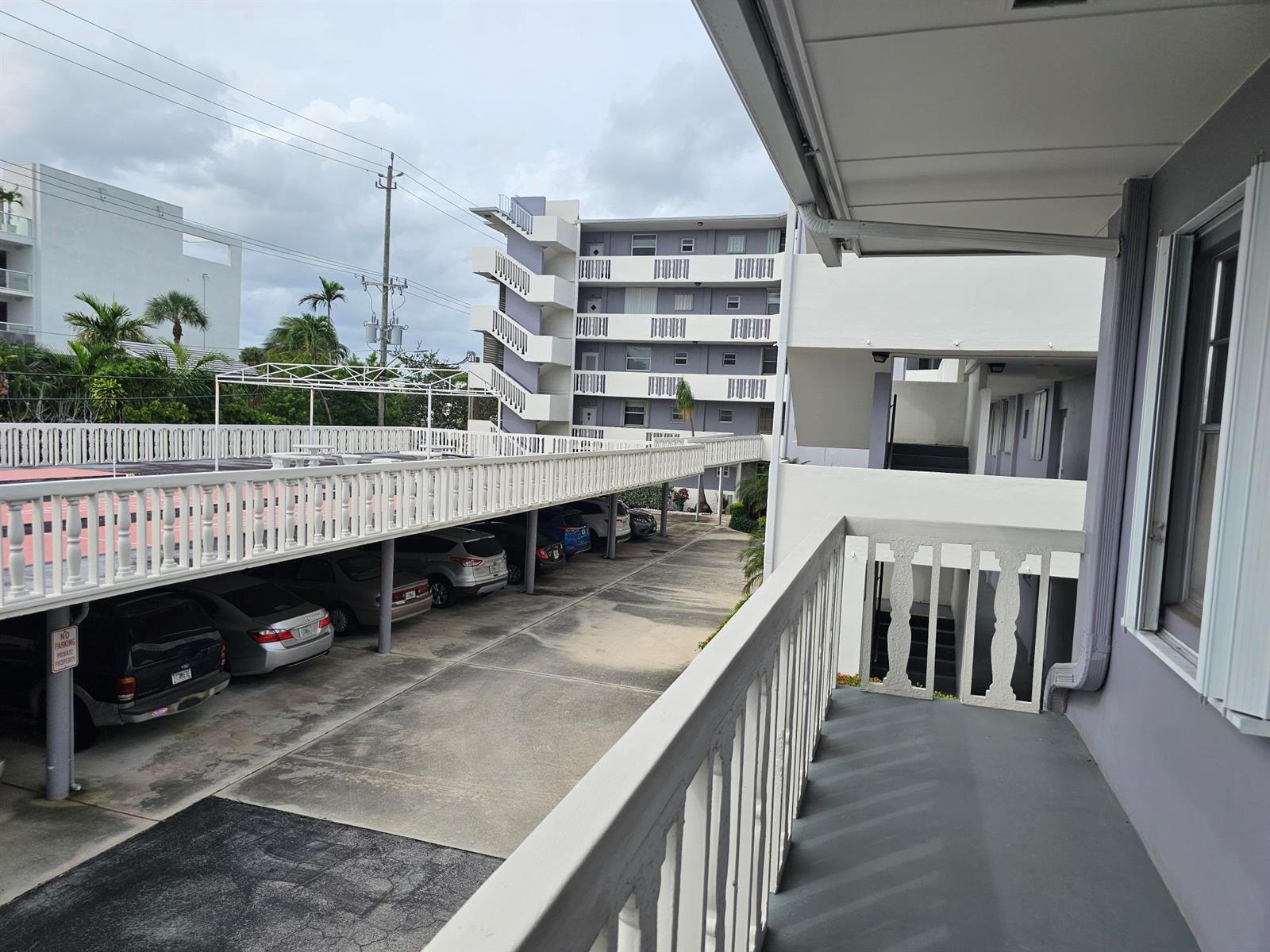 An elevated view of a parking area beneath a balcony and a multi-story apartment building — 17 S Lakeside Drive # 4, FL 33460, FL