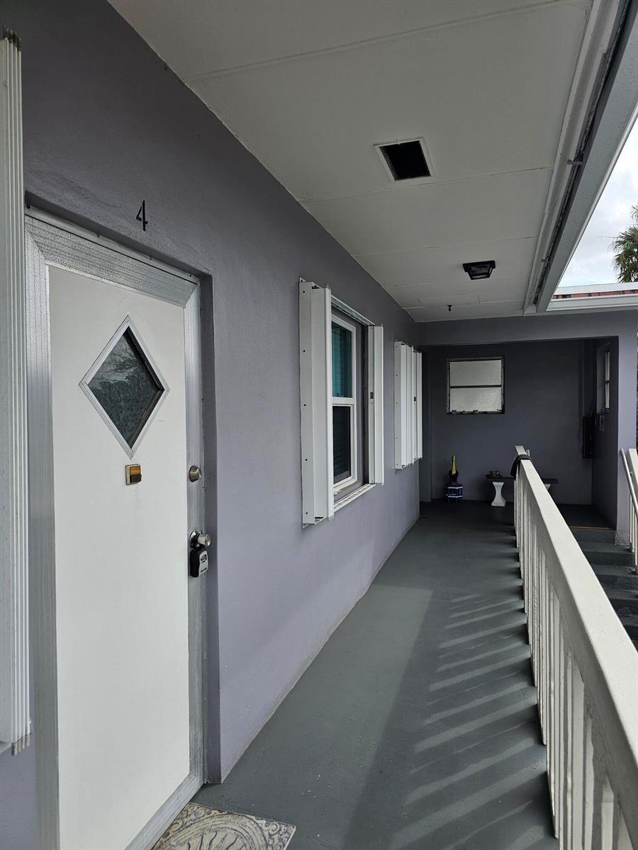 An exterior view of a gray building with a white door labeled number four — 17 S Lakeside Drive # 4, FL 33460, FL