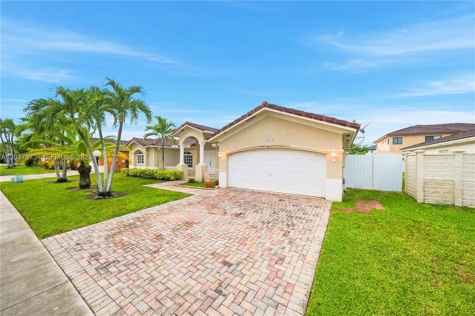 A single-story house features a brick driveway, a two-car garage, and palm trees — 15059 SW 33rd Ter, Miami FL 33185, MIAMI, FL