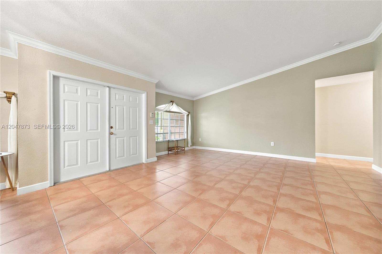 An empty room features light-colored walls, a vaulted ceiling, and terracotta-style floor tiles — 15059 SW 33rd Ter, Miami FL 33185, MIAMI, FL