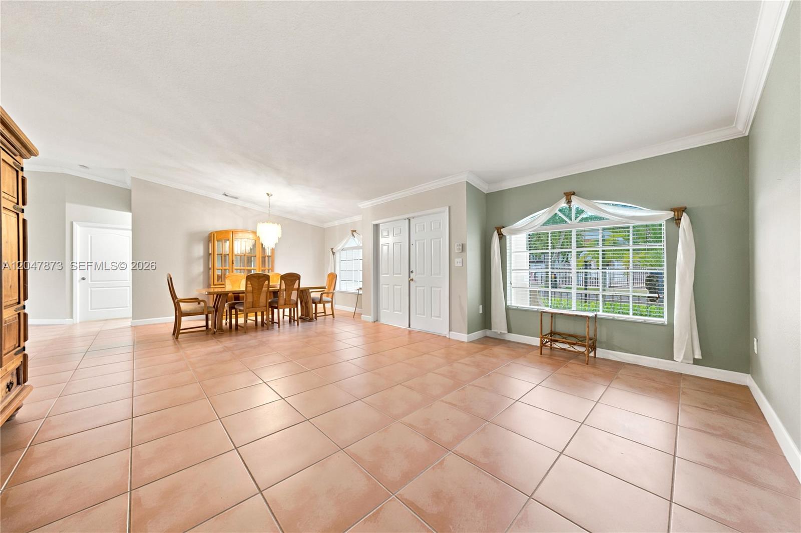 A dining area with tile flooring and a large window sits adjacent to an entryway — 15059 SW 33rd Ter, Miami FL 33185, MIAMI, FL
