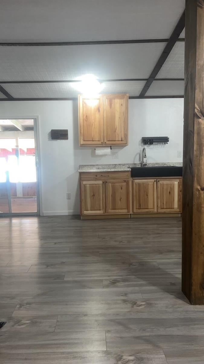 A kitchen features light wood cabinets, a dark sink, and gray wood-look flooring — 1515 NE 342nd Trail, Okeechobee FL 34972, OKEECHOBEE, FL