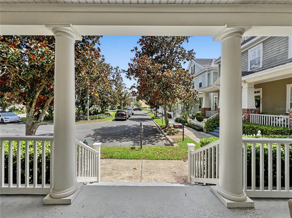 A view from a covered front porch looking out toward a residential street and houses — 1006 SANDLACE COURT, CELEBRATION, FL