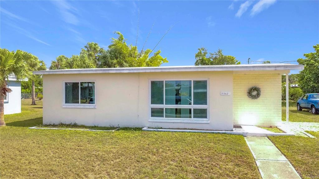 A single-story, light-colored house with a flat roof and a front walkway — 21362 HEPNER AVENUE, PORT CHARLOTTE, FL