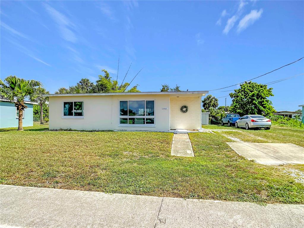A single-story house with a light-colored exterior, a large front window, and a concrete driveway — 21362 HEPNER AVENUE, PORT CHARLOTTE, FL