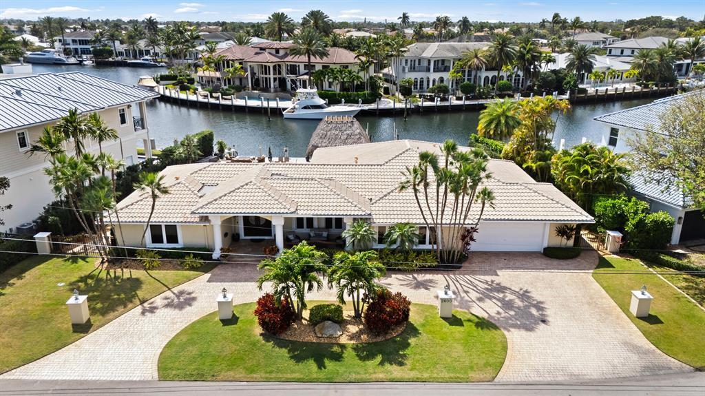 An aerial view shows a single-story house with a tiled roof, driveway, and waterfront backyard — 2600 NE 33rd Street, Lighthouse Point FL 33064, LIGHTHOUSE POINT, FL