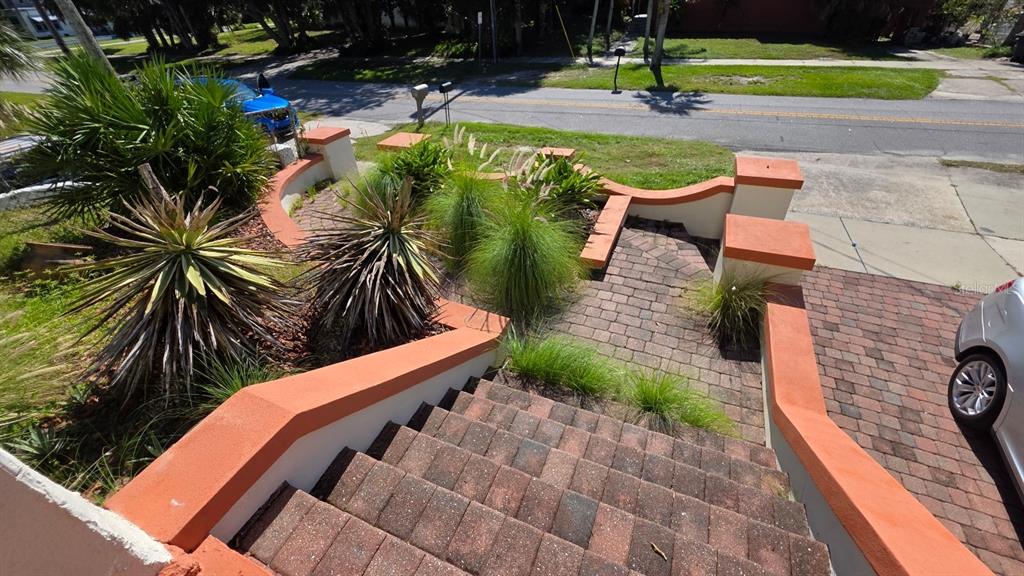 An elevated view of brick stairs leading down to a landscaped walkway and driveway — 213 JESSAMINE BOULEVARD, DAYTONA BEACH, FL