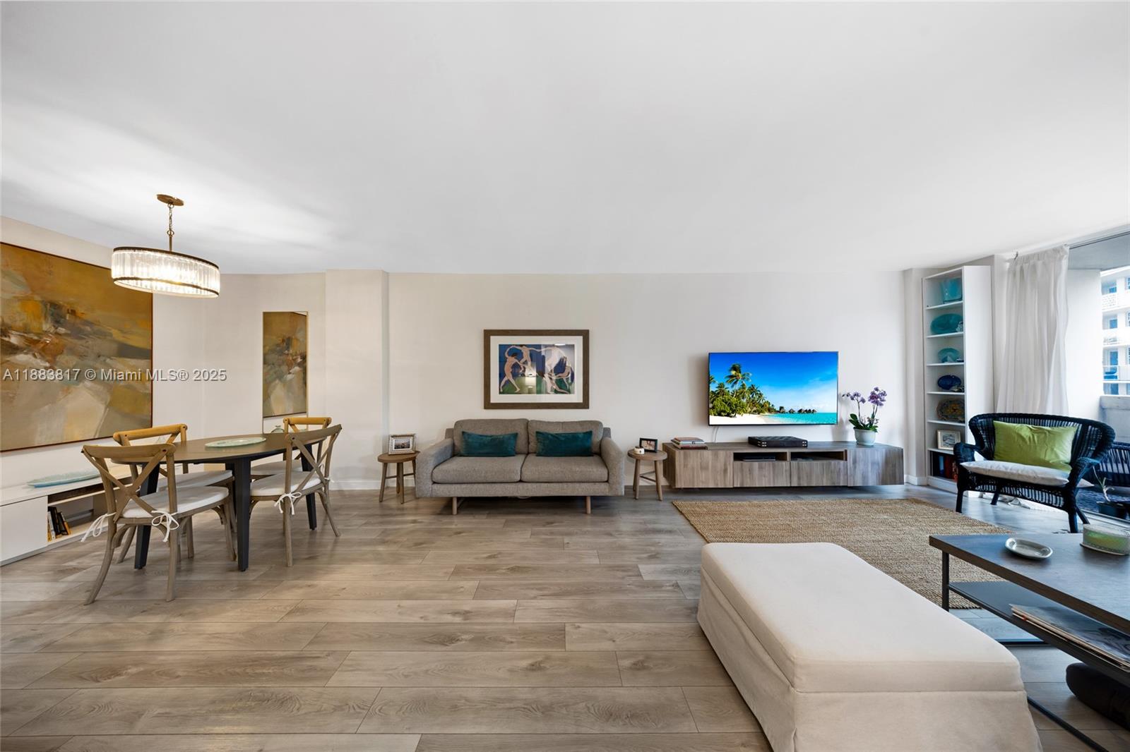 A living and dining room with wood-look flooring, a grey sofa, and a television — 800 West Ave # 338, Miami Beach FL 33139, MIAMI BEACH, FL