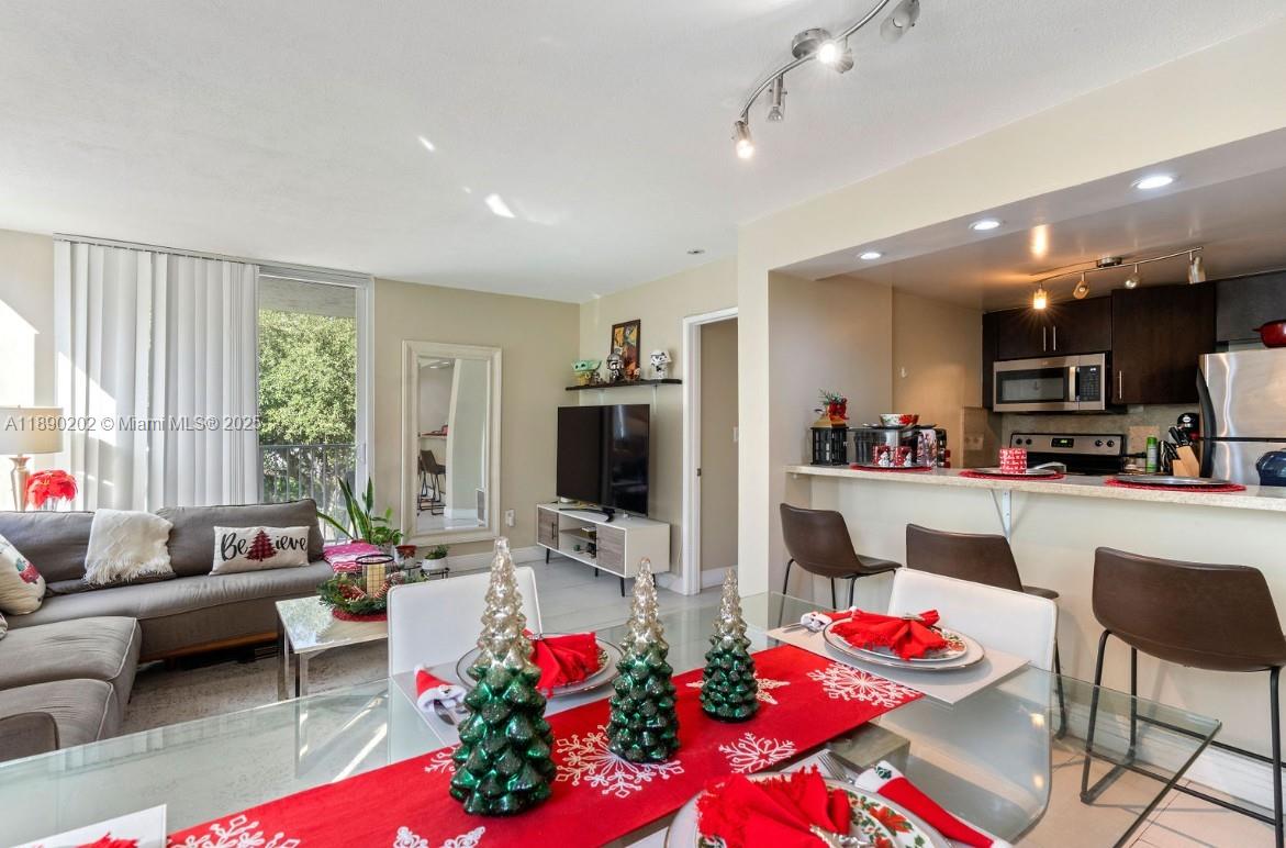 A dining area with a glass table leads into a living room and open kitchen — 800 N Miami Ave # 209, Miami FL 33136, MIAMI, FL