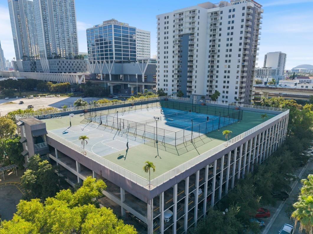 An elevated outdoor sports complex features tennis and basketball courts atop a parking garage structure — 800 N Miami Ave # 209, Miami FL 33136, MIAMI, FL