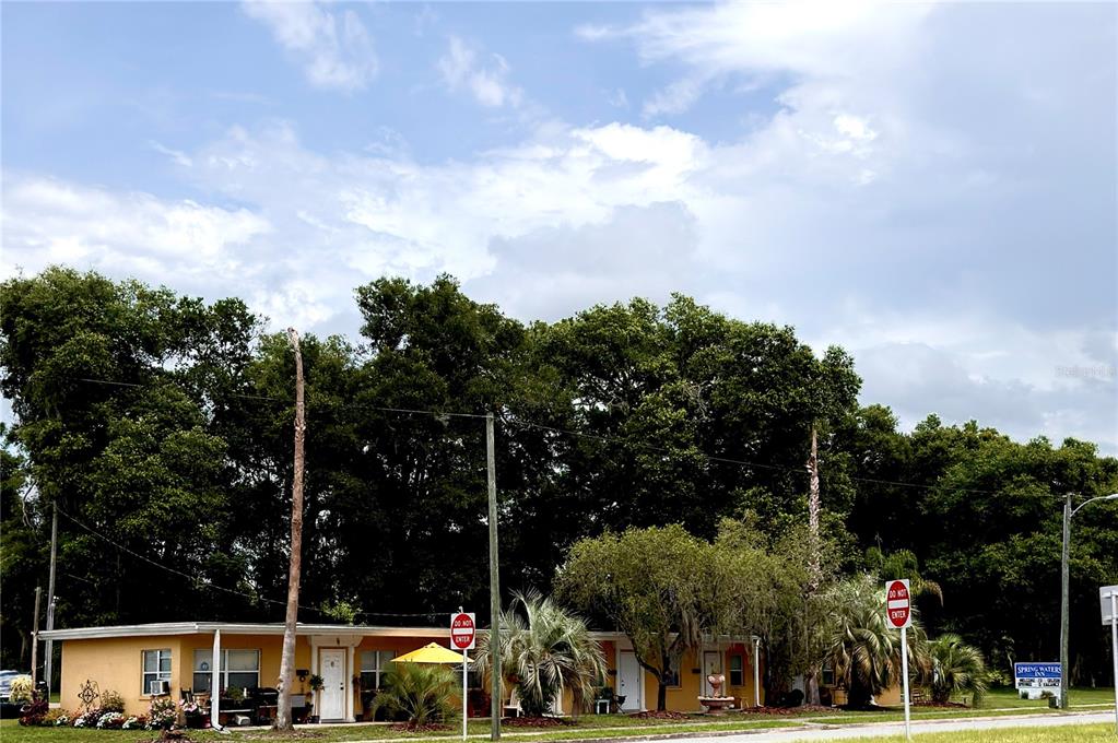 A single-story yellow motel building with a flat roof sits in front of dense trees — 4851 US HIGHWAY 17 HIGHWAY, DE LEON SPRINGS, FL