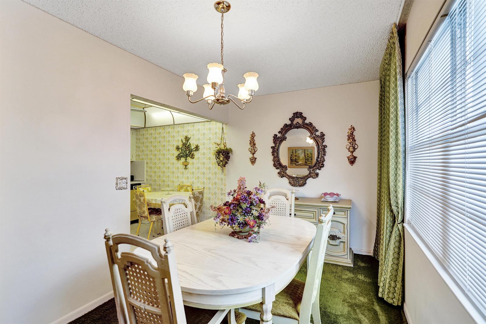 A dining room features a white oval table, chandelier, ornate mirror, and green carpet — 2049 Lyndhurst, Deerfield Beach FL 33442, DEERFIELD BEACH, FL