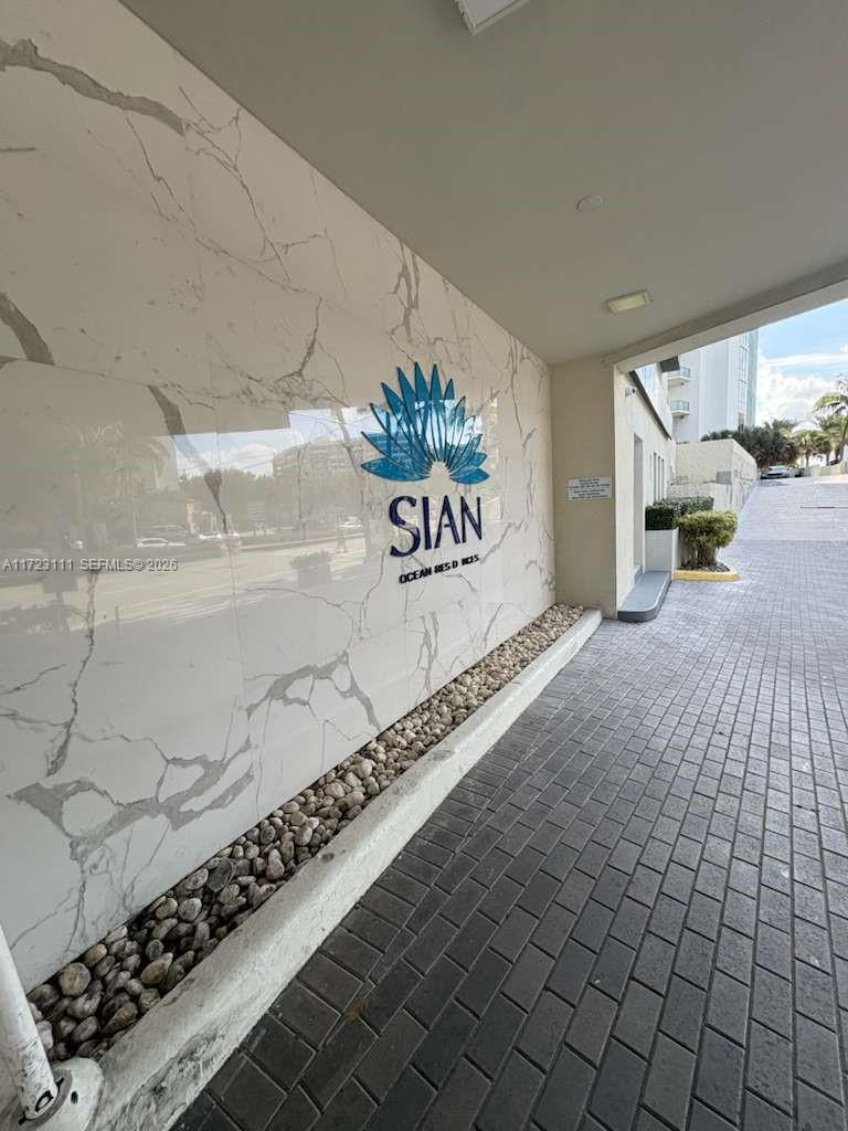 A marble wall features the Sian Ocean Residences logo next to a paved driveway — 4001 S Ocean Dr # 10D, Hollywood FL 33019, HOLLYWOOD, FL