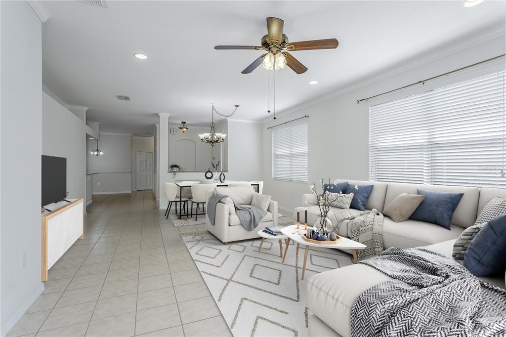A bright living room features tile floors, a ceiling fan, and a sectional sofa — 8415 TAROCCO COURT, LAND O LAKES, FL