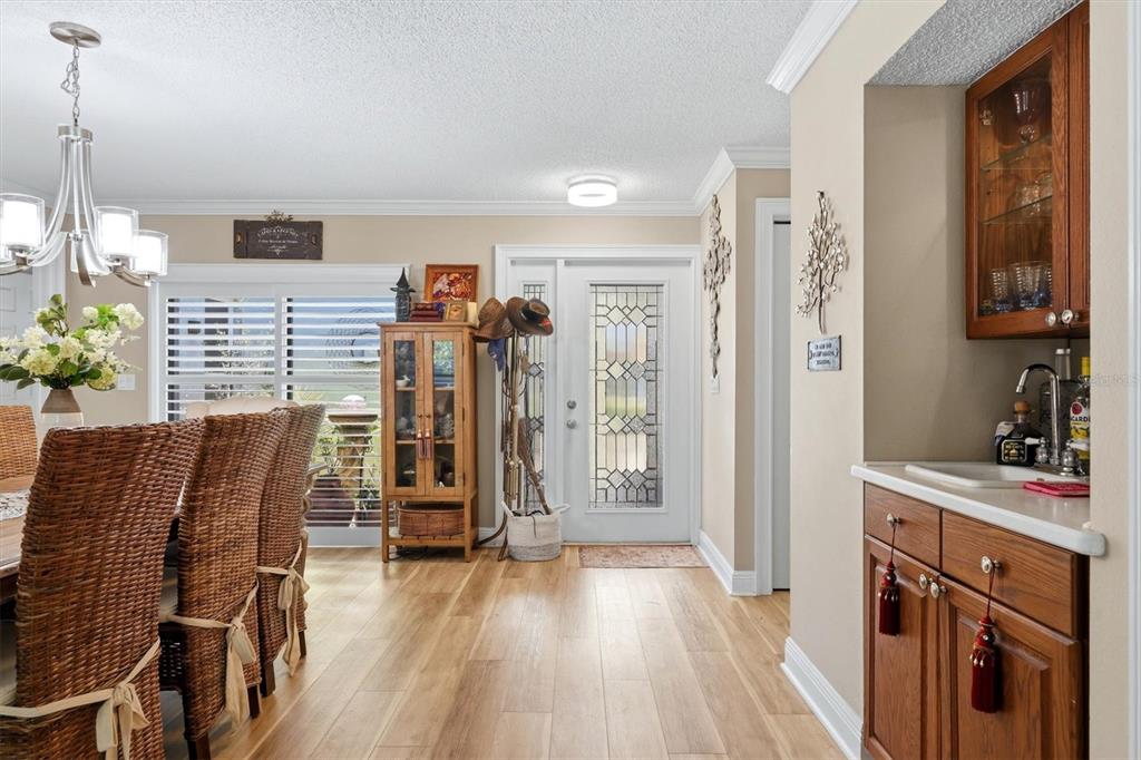 A dining area with a wet bar, wood flooring, and a glass-paneled front door — 3828 EASTON STREET, SARASOTA, FL